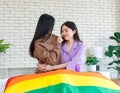 Two Asian beautiful female lesbian girlfriends lover couple in casual outfits sitting posing hugging cuddling embracing on bed in Royalty Free Stock Photo