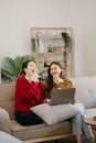 Two asian beauty smiling young women sitting on sofa Attractive casual girl feel happy and relax,having fun watch comedy video on Royalty Free Stock Photo