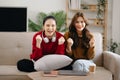 Two asian beauty smiling young women sitting on sofa Attractive casual girl feel happy and relax,having fun watch comedy video on Royalty Free Stock Photo