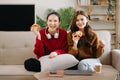 Two asian beauty smiling young women sitting on sofa Attractive casual girl feel happy and relax,having fun watch comedy video on Royalty Free Stock Photo