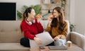 Two asian beauty smiling young women sitting on sofa Attractive casual girl feel happy and relax,having fun watch comedy video on Royalty Free Stock Photo