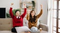 Two asian beauty smiling young women sitting on sofa Attractive casual girl feel happy and relax,having fun watch comedy video on Royalty Free Stock Photo