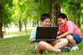2 Asian boys smiling, laughing, sitting, studying computer Royalty Free Stock Photo