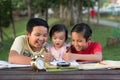 Two asian brothers playing with their little sister drawing together Royalty Free Stock Photo