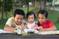 Two asian brothers playing with their little sister drawing together Royalty Free Stock Photo