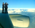 Two of asian business man standing on jet plane wing over white