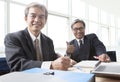 two of asian business man toothy smiling face ,relaxing in office life