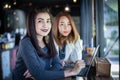 Two Asian business women using notebook working and Discussion of the important contract at coffee shop