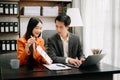 Two Asian businesswoman discuss investment project working and planning strategy with tablet laptop computer in office