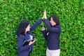 Two asian businesswoman high five for business success outside o