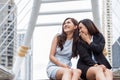 Two Asian businesswomen gossip joke story at outdoors city after finished working. Business women coworker and friendship concept Royalty Free Stock Photo