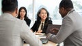 Two Asian businesswomen are having a meeting with an African American and an Indian businessman Royalty Free Stock Photo