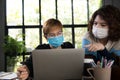 Two Asian businesswomen in quarantine and social distancing wearing surgical mask while working at office during Covid-19 Coronavi