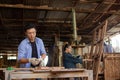 A carpenter is working in a woodworking office. Asian male carpenter using electric circular saw cut wood Royalty Free Stock Photo