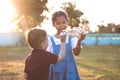 Two asian child girl and boy playing with toy wooden airplane in the park together at sunset time Royalty Free Stock Photo