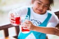 Two asian child girl clinking glasses of fresh red juice water Royalty Free Stock Photo