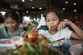 Two asian child girls eating delicious fried fish and salad in the restaurant Royalty Free Stock Photo