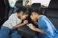 Two asian child girls eating dessert together while traveling in the car. Royalty Free Stock Photo