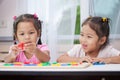 Two asian child girls having fun to play and learn magnetic alphabet Royalty Free Stock Photo