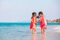 Two asian child girls holding hand each other and playing together on beach near the sea in summer vacation