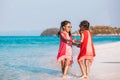 Two asian child girls holding hand each other and playing together on beach near the sea in summer vacation