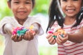 Two asian child girls holding sweet candies in thier hands Royalty Free Stock Photo