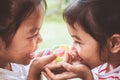 Two asian child girls holding sweet candies in thier hands