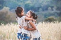 Two asian child girls hugging each other and playing together in the barley field Royalty Free Stock Photo