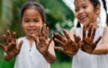 Two asian child girls showing dirty hands after planting the tree together in the garden Royalty Free Stock Photo