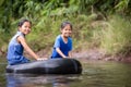 Two asian child girls sitting on rubber ring and playing in the river together with fun Royalty Free Stock Photo