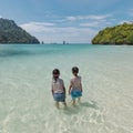 Two asian child girls standing and playing in the sea and enjoying with beautiful nature together with fun. Royalty Free Stock Photo