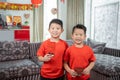 Two asian chinese boys smile wearing red shirts with angpau Royalty Free Stock Photo