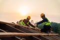 Two asian construction worker install new roof, Roofing tools, Electric drill used on new roofs of wooden roof structure, Teamwork