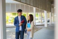 Two Asian couple university students walking and talking to class in walkway on a beautiful sunny day in campus Royalty Free Stock Photo