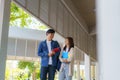 Two Asian couple university students walking and talking to class in walkway on a beautiful sunny day in campus Royalty Free Stock Photo