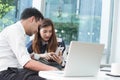 Two asian coworkers use laptop and smartphone work together having coffee Royalty Free Stock Photo