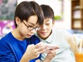 Two asian elementary schoolboys playing game with cellphone Royalty Free Stock Photo