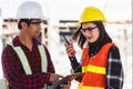 Two Asian engineer foreman architect worker man and woman talking at building construction site Royalty Free Stock Photo