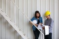 Two Asian engineers, man and woman, discussing in construction site