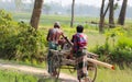 Two asian farmers carrying a diesel engine water pump