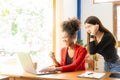 Two Asian female accountants excitedly looking at laptop screen Happy Asian business colleagues