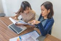 Two Asian female accountants working together on financial report document