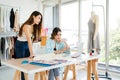 Two Asian female fashion designers or dressmakers brainstormed and discuss the design of the new collection with samples. Royalty Free Stock Photo