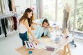 Two Asian female fashion designers or dressmakers brainstormed and discuss the design of the new collection with ssamples. Royalty Free Stock Photo