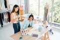 Two Asian female fashion designers or dressmakers brainstormed and discuss the design of the new collection with samples. Royalty Free Stock Photo