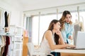 Two Asian female fashion designers or dressmakers brainstormed and discuss the design of the new collection with samples. Royalty Free Stock Photo