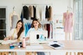 Two Asian female fashion designers or dressmakers brainstormed and discuss the design of the new collection with samples. Royalty Free Stock Photo