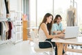 Two Asian female fashion designers or dressmakers brainstormed and discuss the design of the new collection. Royalty Free Stock Photo