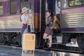 Two Asian female tourist friends are at the train station. Waiting for the train to travel to the provinces together on