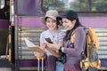 Two Asian female tourist friends are at the train station. Waiting for the train to travel to the provinces together on